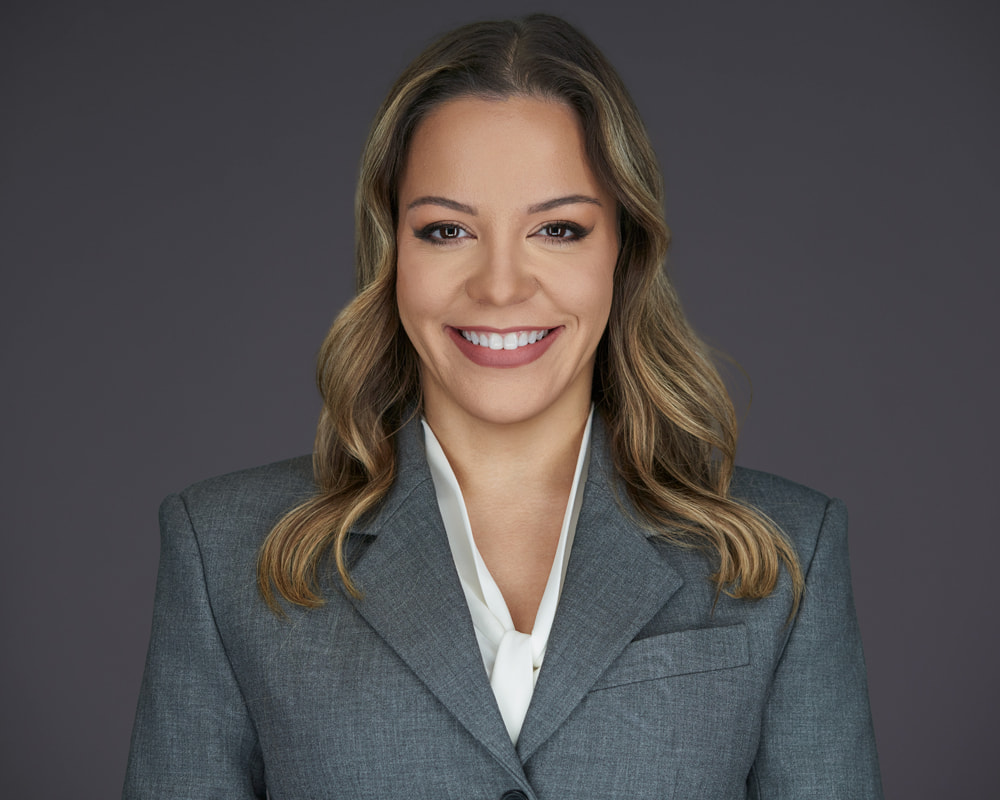 Professional headshot of Lisandra Estevez wearing a gray blazer and white blouse, Florida healthcare attorney at Di Pietro Partners
